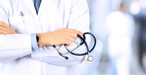 Portrait an unknown male doctor holding a stethoscope behind